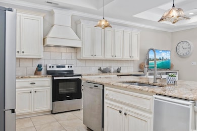 Kitchen featuring a sink, backsplash, custom range