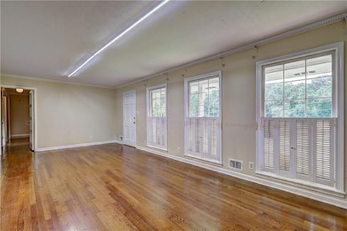 Spare room featuring wood finished floors and ornamental molding