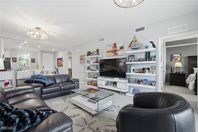 Living room with recessed lighting, arched walkways, light tile patterned floors, and a chandelier