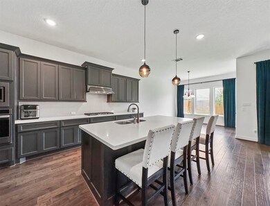 Another view of the kitchen. You will feel the custom feel of elegance, the bright and pleasant ambiance will set the tone for the day. The color of the cabinets, walls, and the lightning coordinates perfectly making this a welcoming space.