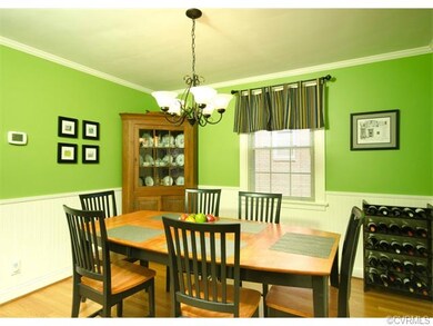 The dining room has hardwood floors, crown molding, and newly installed wainscoting.
