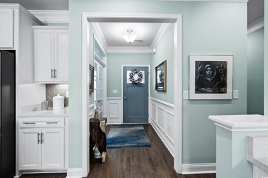 Foyer with crown molding and dark hardwood / wood-
