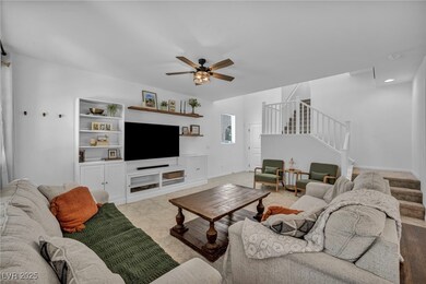 Living room featuring stairway, a ceiling fan, bas