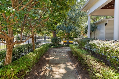 Stone walkways, wrought-iron fencing, original brick and manicured hedges add incredible charm to the front yard.
