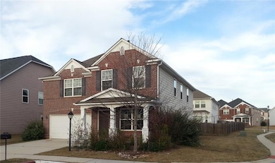 Traditional home featuring brick siding, an attached garage, driveway, and a residential view