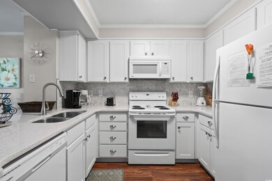 Kitchen with white cabinets, white appliances, orn