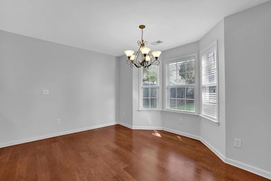 Empty room featuring a chandelier and wood finished floors