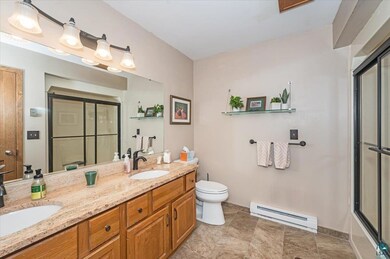Bathroom with tile patterned floors, toilet, baseb