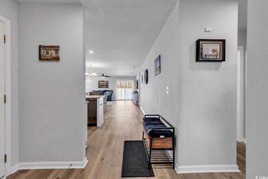 Hallway featuring baseboards, an inviting chandeli