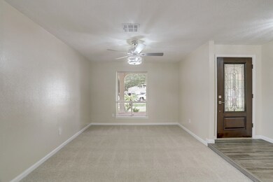 Living room with new carpet and new ceiling fan. Front door is also new