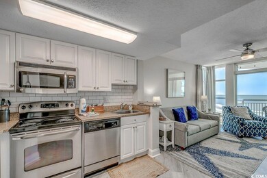 Kitchen with white cabinets, sink, light hardwood 