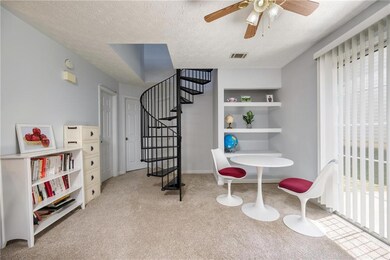 Living area with carpet, stairs, ceiling fan, and a textured ceiling