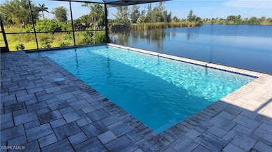 View of pool featuring a water view and glass encl