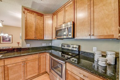 Beautiful kitchen features gleaming granite tops, 