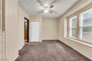 Unfurnished bedroom featuring ceiling fan and carpet flooring
