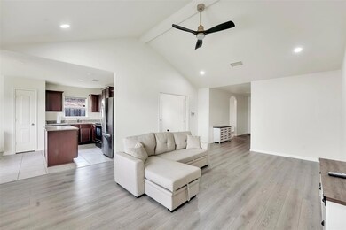 Living room with high vaulted ceiling, ceiling fan, beam ceiling