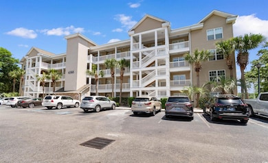 View of apartment building / complex with uncovered parking
