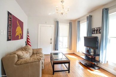 Living area featuring a chandelier and hardwood /