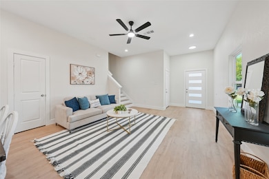 Living area featuring stairs, light wood-type flooring, recessed lighting, and ceiling fan