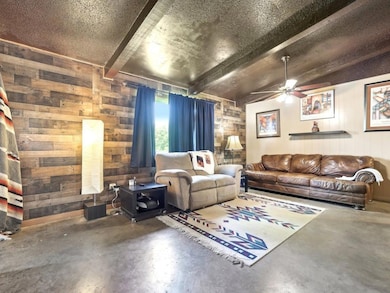 Living area with wooden walls, concrete floors, c