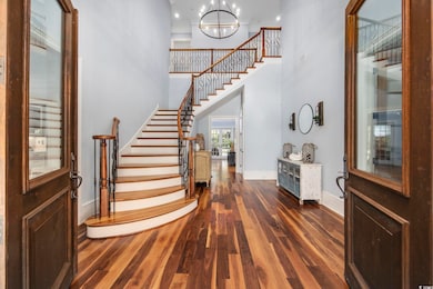 Entrance foyer with a notable chandelier and dark 