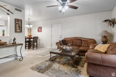 Living area featuring carpet, ceiling fan, and a chandelier
