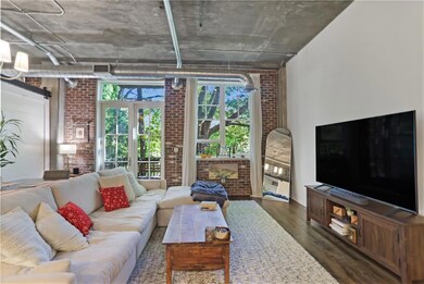 Living area with brick wall and dark wood-style floors