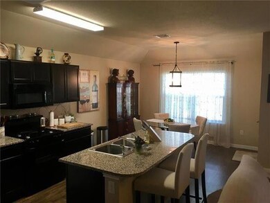 Kitchen with black appliances, lofted ceiling, a 