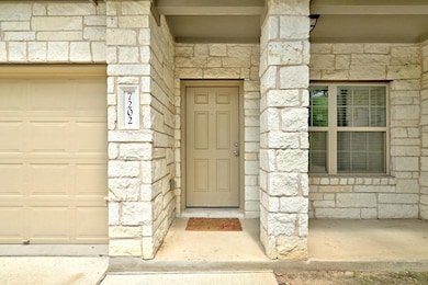 Property entrance with stone siding and a garage