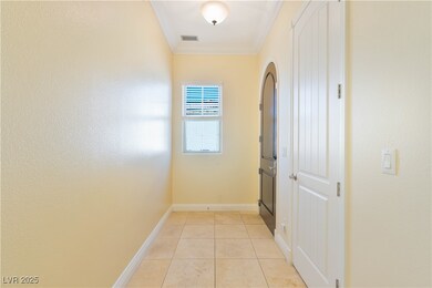 Corridor with crown molding, light tile patterned