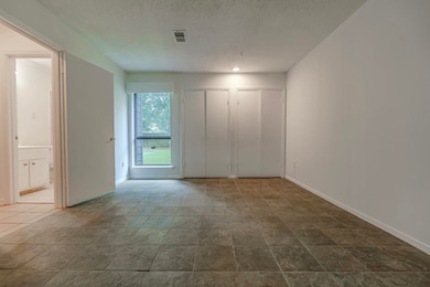Tiled empty room featuring a textured ceiling