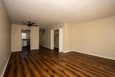 Unfurnished living room with baseboards, dark wood