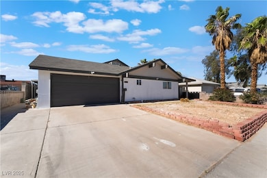 Ranch-style home with driveway, a garage, and stuc
