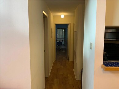 Corridor featuring wood finished floors and baseb