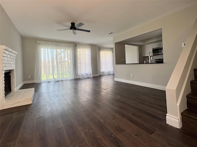 Unfurnished living room featuring a ceiling fan, 