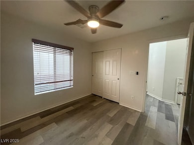 Unfurnished bedroom with dark wood-type flooring, a ceiling fan, and a closet