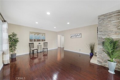 Large Living Room with Wood Laminate Flooring, Recessed Lighting, Stacked Stone Fireplace, and Dual Pane French Windows and Sliders