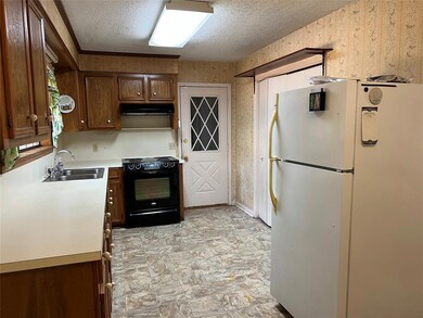 Kitchen with range and refrigerator remaining.