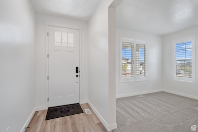 Entryway with baseboards and light wood-style floors