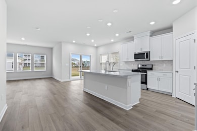 Kitchen with white cabinets, light hardwood / wood