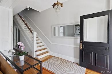 Entrance foyer with wood-type flooring and a notable chandelier