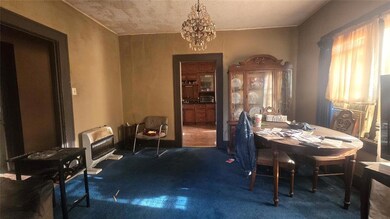 Carpeted dining area with a notable chandelier