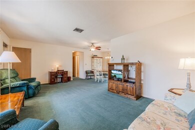 Living room with carpet floors, visible vents, and