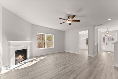 Stock PhotoUnfurnished living room featuring a ceiling fan, a premium fireplace, light wood-style floors, baseboards, and recessed lighting