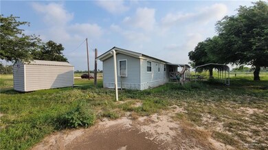View of side of property featuring a carport, an outdoor structure, and a storage shed
