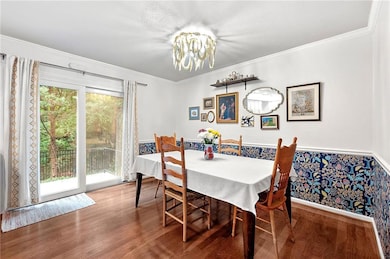 Dining area featuring wood finished floors, a chandelier, and ornamental molding