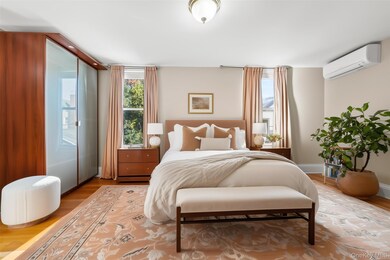 Bedroom featuring wood finished floors and a wall mounted air conditioner