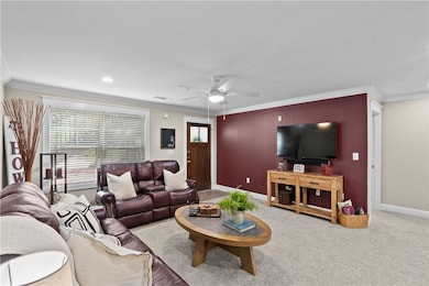 Carpeted living area featuring crown molding and c
