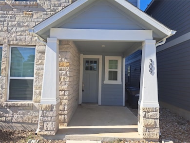 Doorway to property with stone siding and a porch