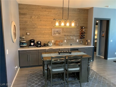 Indoor wet bar featuring wooden walls, baseboards,
